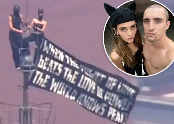 Kissing-daredevils scale Empire State Building antenna, hanging flag 1,454 feet over NYC with cringe message